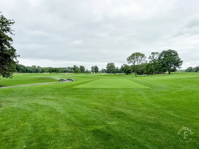 A fairway at Adare Manor with a bunker along one side and the manor in the distance.