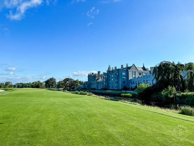 A green and flagstick at Adare Manor, with a bunker in front and old trees around the hole.