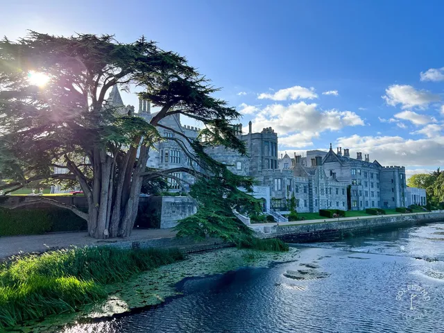A close view of a flagstick at Adare Manor, with the manor in the background.