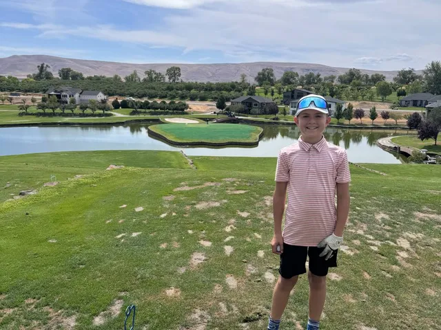 A green and flagstick at Apple Tree, with a bunker in front and the hills behind.