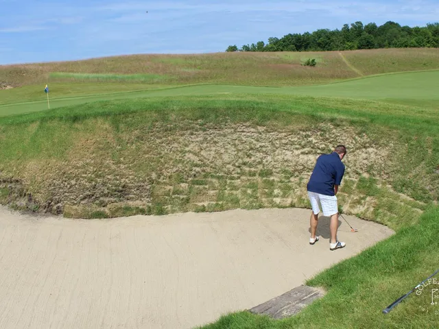 A green and flagstick at Arcadia Bluffs, with a bunker in front and the lake behind the hole.