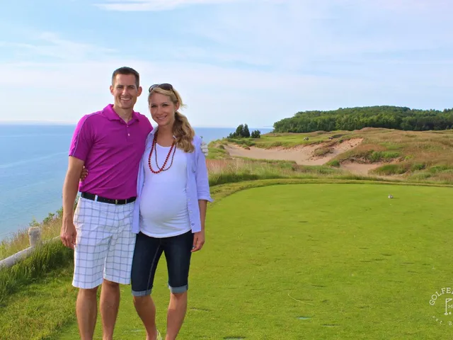 A green and flagstick at Arcadia Bluffs above the water, with the lake filling the background.