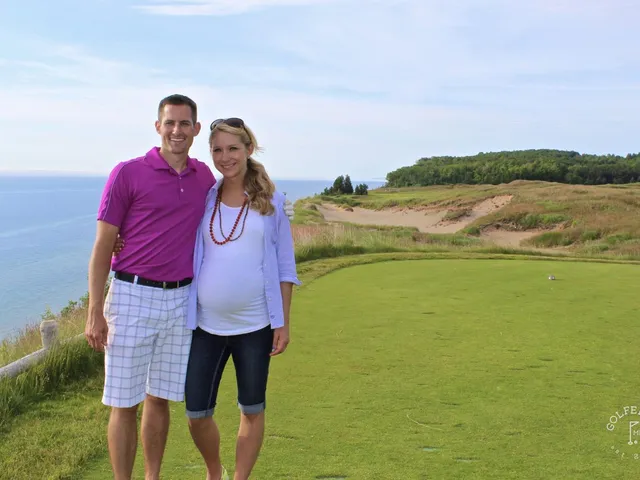 A golfer hitting a shot from the bluff at Arcadia Bluffs, with Lake Michigan behind the hole.