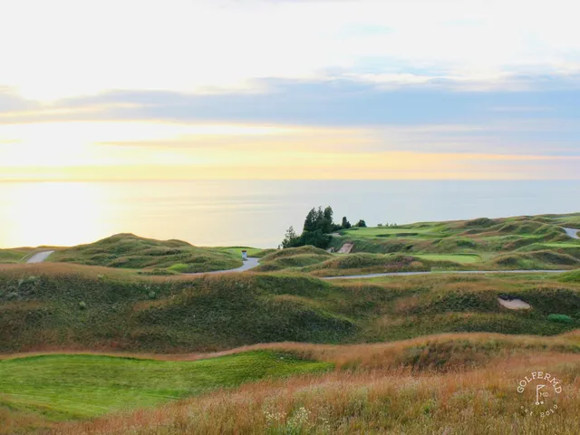Golfers on a tee at Arcadia Bluffs, with the lake and the fairway behind them.