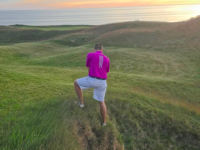 A golfer putting on a green at Arcadia Bluffs, with the lake beyond the hole.