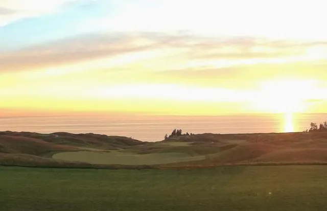 A wide fairway at Arcadia Bluffs, with the bluffs and Lake Michigan on the horizon.
