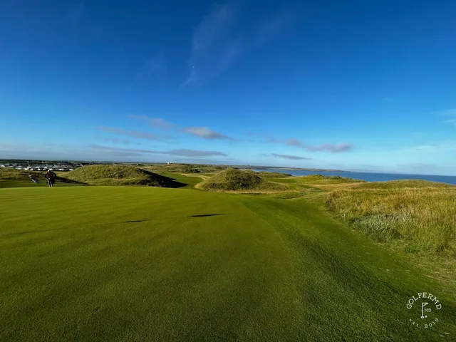 Golfers on a tee on the Old Course, with the Atlantic behind them.