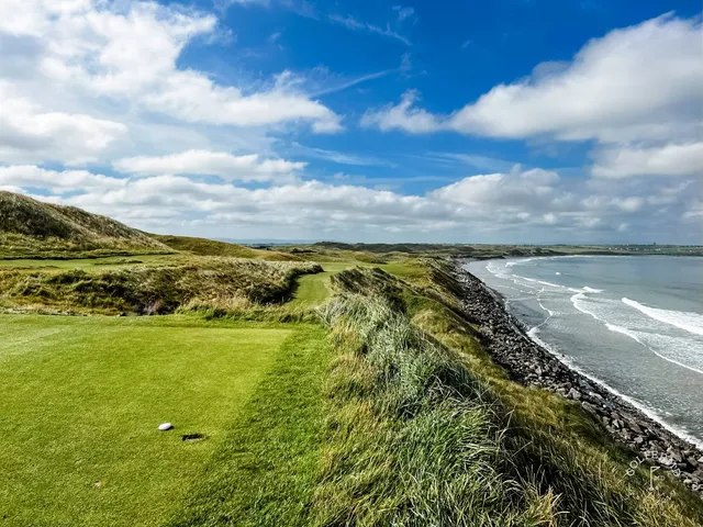 A fairway on the Old Course with a bunker along one side and the Atlantic ahead.