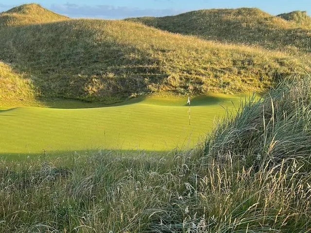 A wide hole on the Old Course, the fairway running through the dunes to the water.