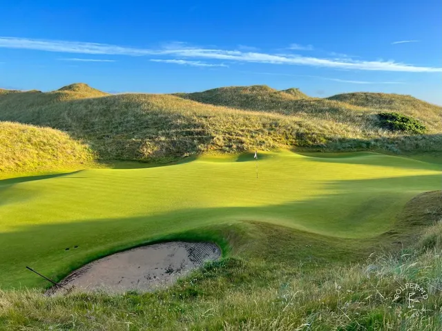 A fairway on the Old Course with the town and the ocean in the distance.