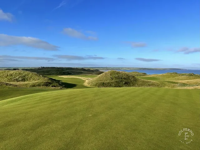 A golfer putting on the Old Course, with the Atlantic behind the green.
