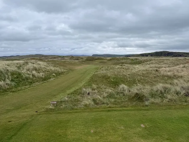 A wide view of the Glashedy Links, with dunes and the Atlantic on the horizon.