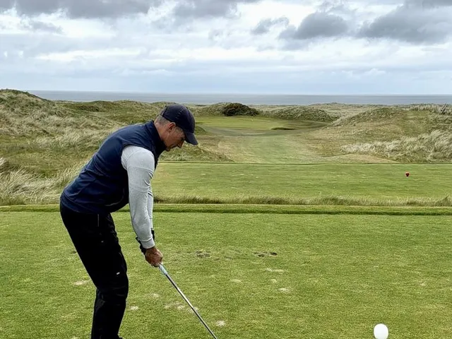 A close view of a green and flagstick on the Glashedy Links, with the water behind it.