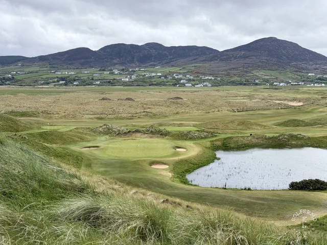A green and flagstick on the Glashedy Links, seen from a rise, with the ocean behind the hole.