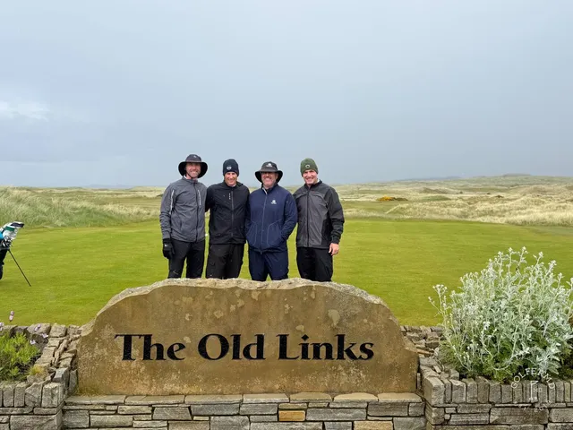A green and flagstick on the Old Links, with a bunker in front and the ocean beyond.