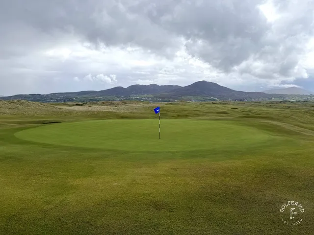 A golfer hitting a shot on the Old Links, with the fairway ahead.