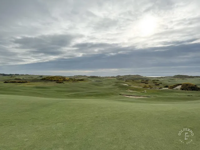A golfer putting on a green at Bandon Dunes, with the ocean beyond the hole.