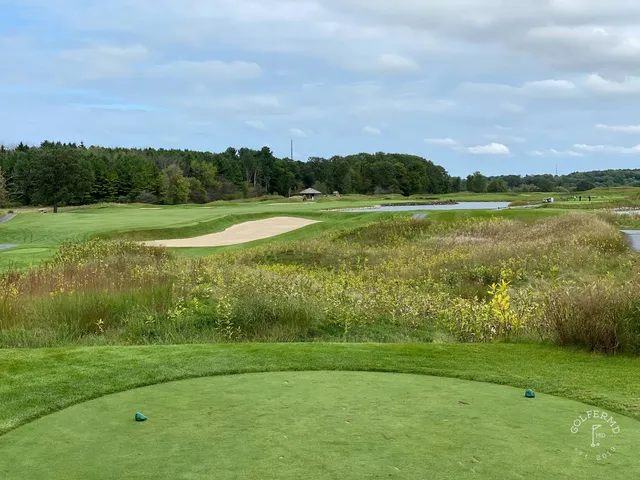 A golfer hitting a shot at Meadow Valleys, with the fairway and the fescue ahead.