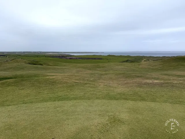 A wide fairway at Carne, with the dunes and the bay in the distance.