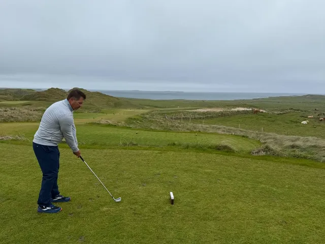 A wide view across Carne, with fairway, dunes, and the water.