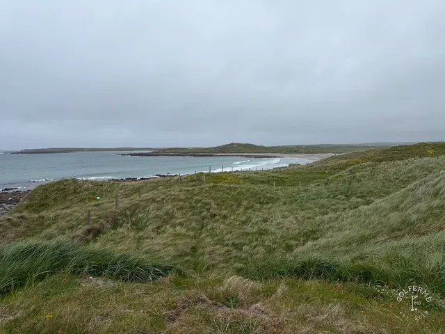 A close view of a flagstick at Carne, framed by the dunes.