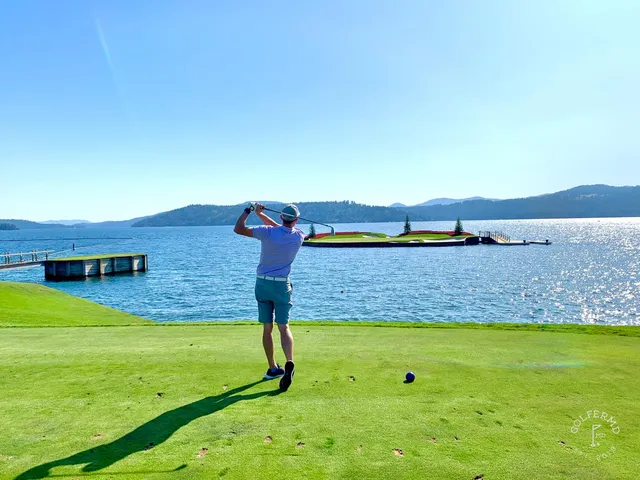 A wide view of the resort course, with pines and the lake on the horizon.