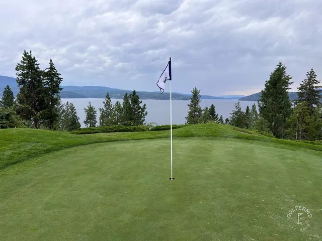 Golfers on a tee at the Coeur d'Alene Resort, with the lake and mountains behind them.