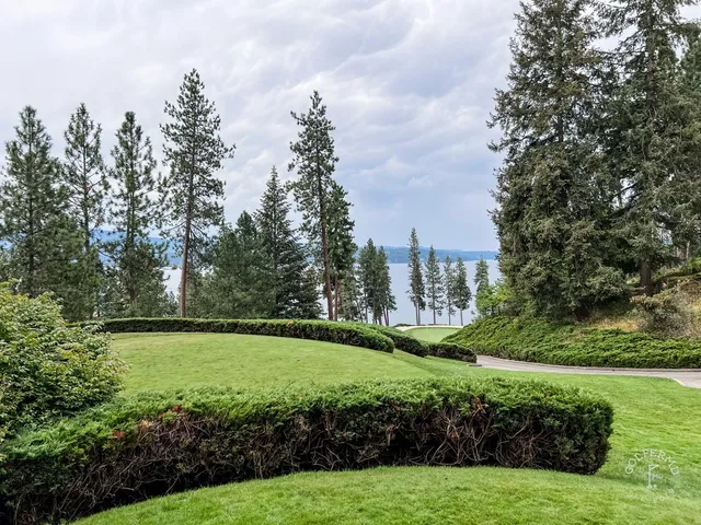 A close view of a green and flagstick at the Coeur d'Alene Resort, with the lake behind the hole.