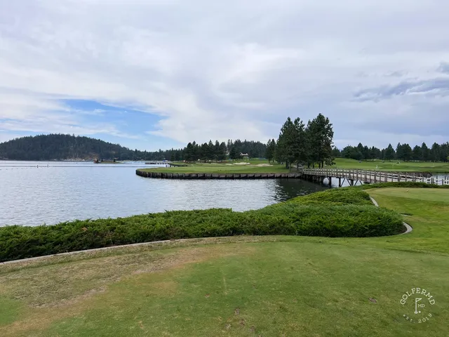 A golfer putting on a green at the Coeur d'Alene Resort, with the lake beyond.