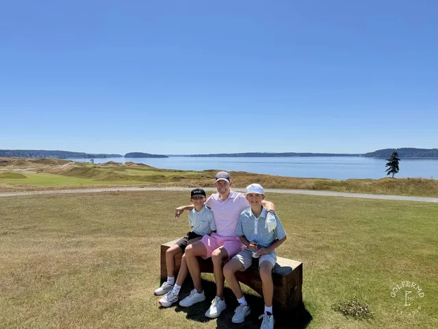 A green and flagstick at Chambers Bay above the water, with a bunker short of the green.