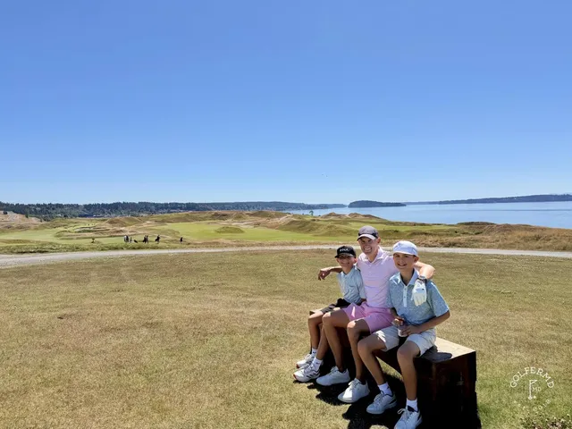 Golfers on a tee at Chambers Bay, with Puget Sound behind them.