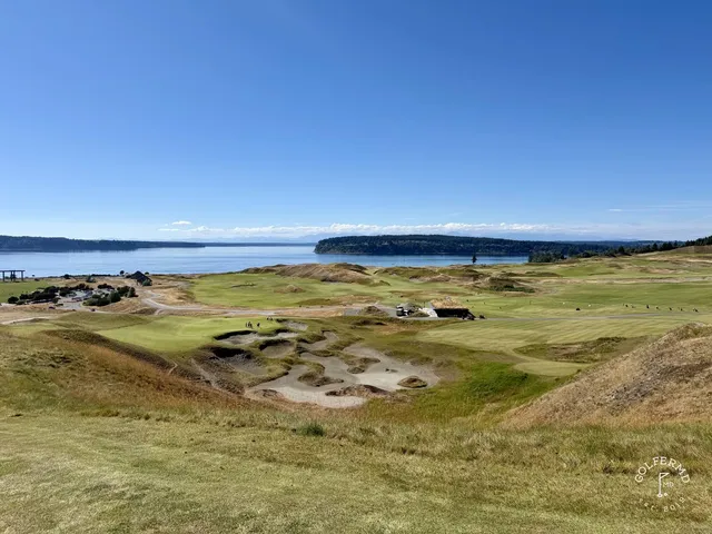 A close view of a green and flagstick at Chambers Bay, with the water behind it.