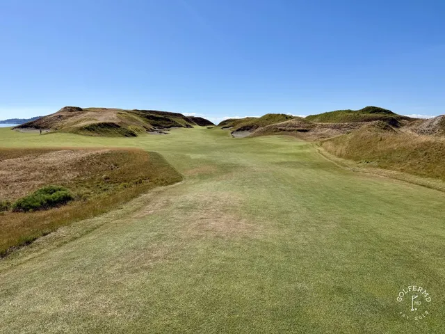 A fairway at Chambers Bay with a bunker along one side and the water ahead.