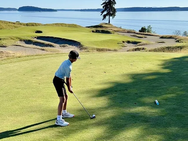 A fairway at Chambers Bay bending through the dunes toward the water.
