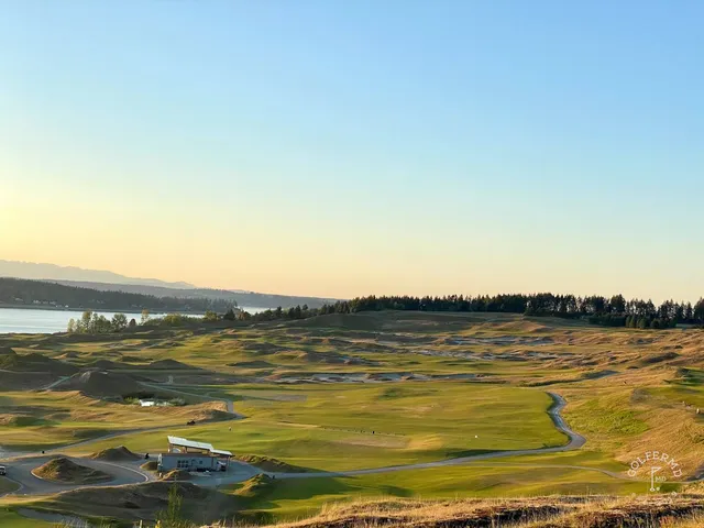 A golfer hitting a shot from the fairway at Chambers Bay, with the water ahead.
