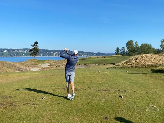 A wide hole at Chambers Bay, with dunes on both sides and the water ahead.