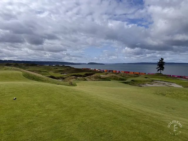 A green and flagstick at Chambers Bay, seen from a rise, with the sound beyond.