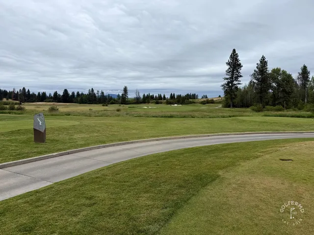 A green and flagstick at Circling Raven, with a sand bunker in front of the hole.