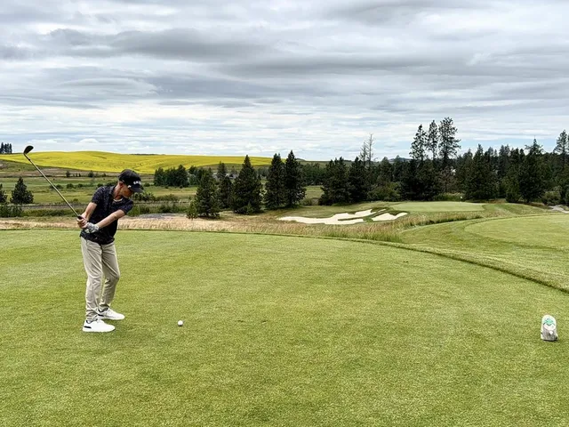 Golfers on a tee at Circling Raven, with the pine forest behind them.