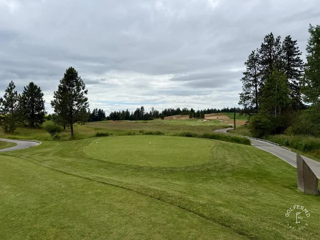 A wide hole at Circling Raven, with a fairway bending through the pines.