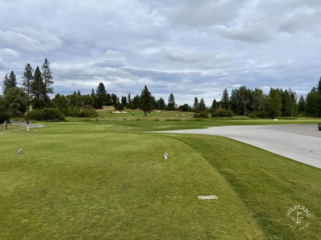 Golfers walking a fairway at Circling Raven, with the pine forest around them.