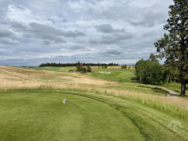 A green and flagstick at Circling Raven, with a bunker wrapping the front of the green.
