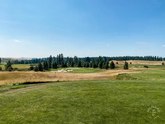 A close view of a green at Circling Raven, with the flagstick and a bunker in front.