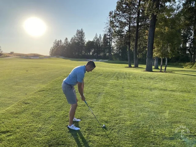 A fairway at Circling Raven with the green visible beyond a bunker.