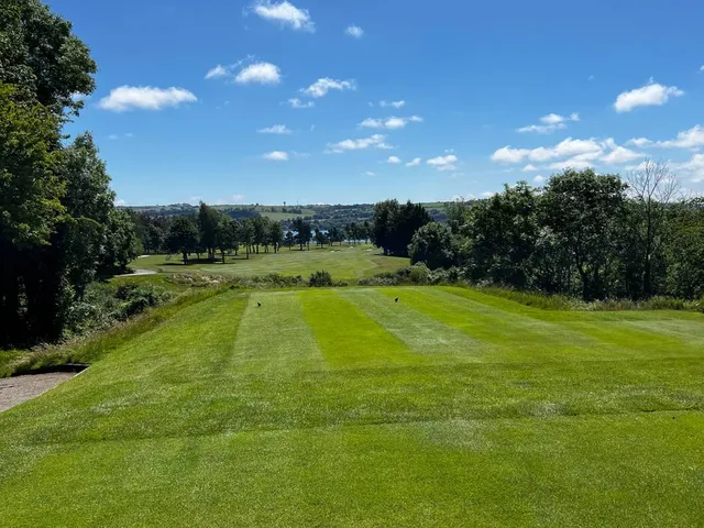 A fairway at Cork Golf Club, with the estuary and the hills beyond.