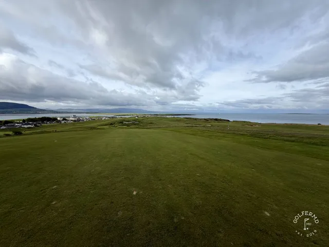 A green and flagstick at Rosses Point above the bay, with a bunker short of the green.