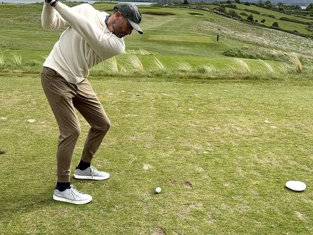 A green and flagstick at Rosses Point, with a deep bunker in front and the ocean beyond.