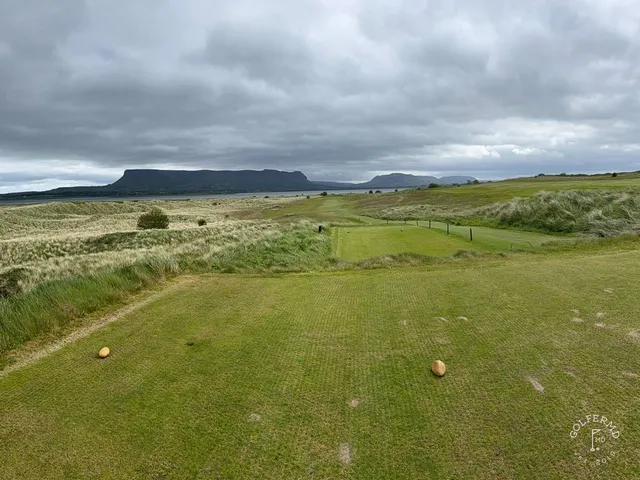A close view of a flagstick at County Sligo, framed by the dunes.