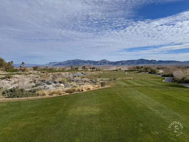 A wide fairway at Coyote Springs running through the desert, with mountains on the horizon.