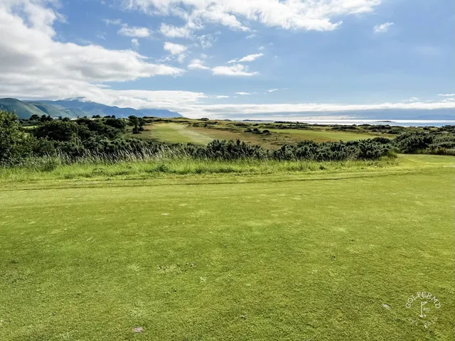 A fairway at Dooks lined with dunes, running toward the water.